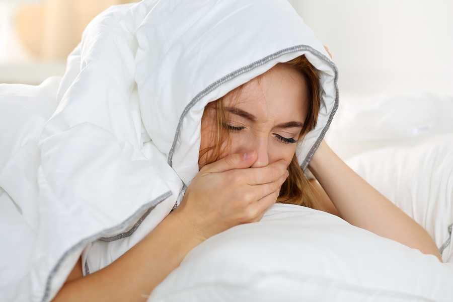 Sick Young Woman Lying In Bed Suffering With Cold
