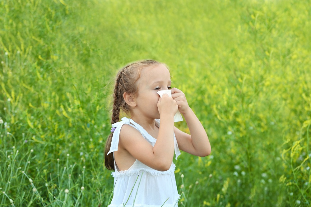 Seasonal allergy. Little girl with tissue outdoor