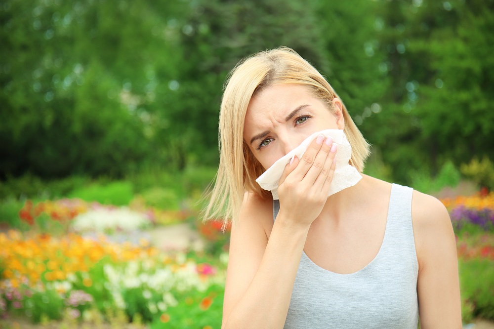 Young woman with allergy outdoors