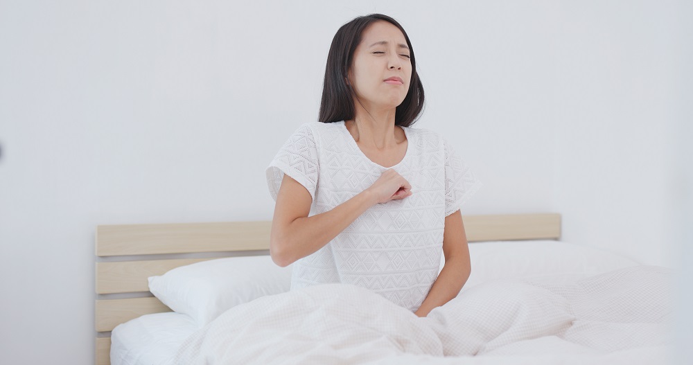 Woman feeling pain and tired on bed