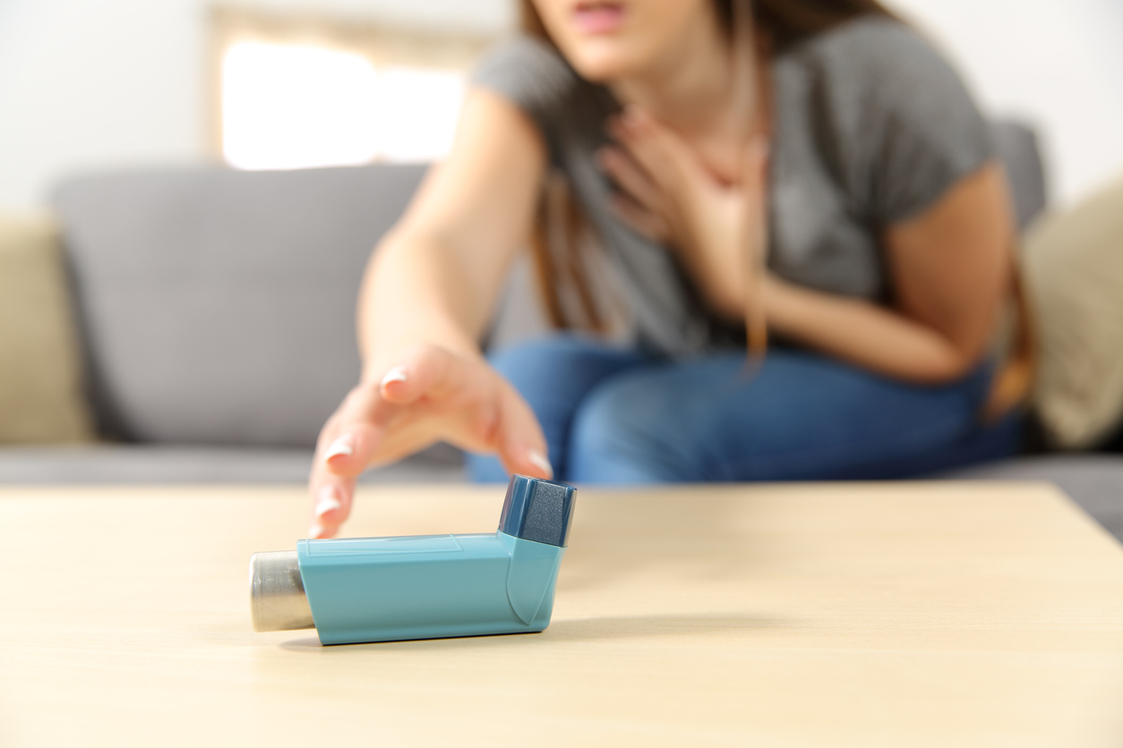 Girl suffering asthma attack reaching inhaler