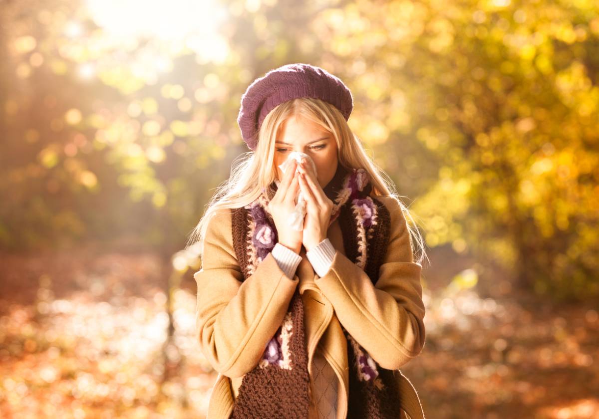 Woman with fall allergies sneezing.