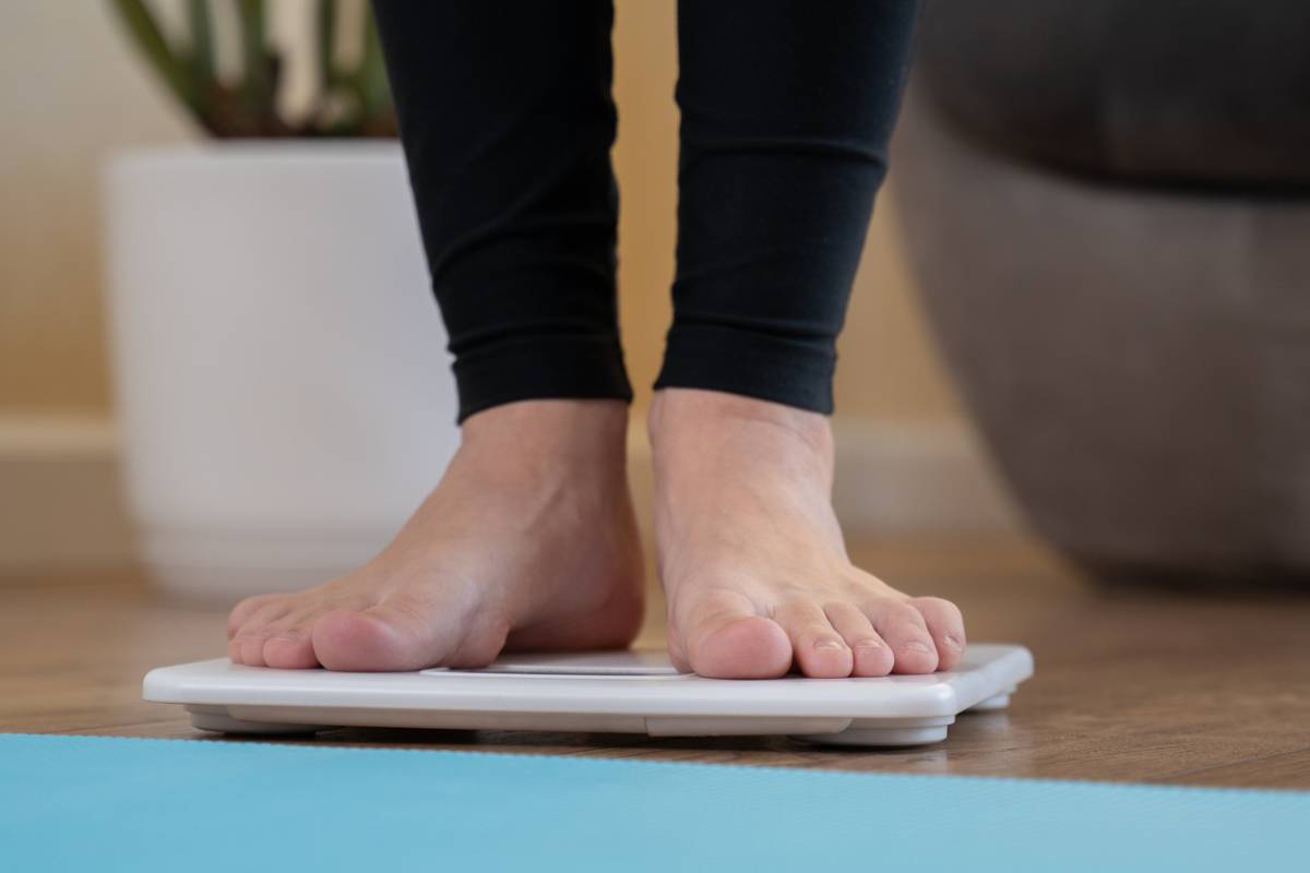 Woman checking her weight on a scale.