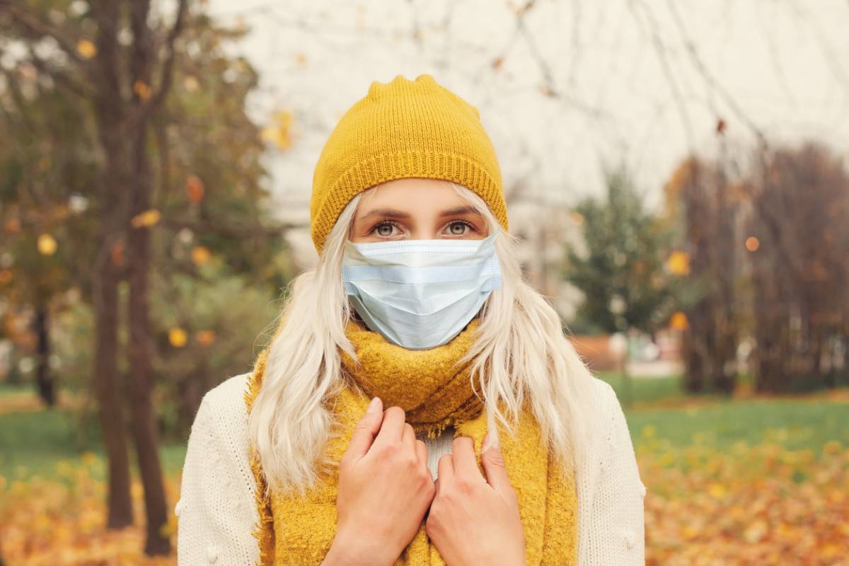 Woman wearing mask who has allergies in autumn.