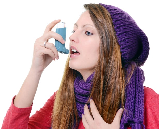 Image of female patient taking inhaler