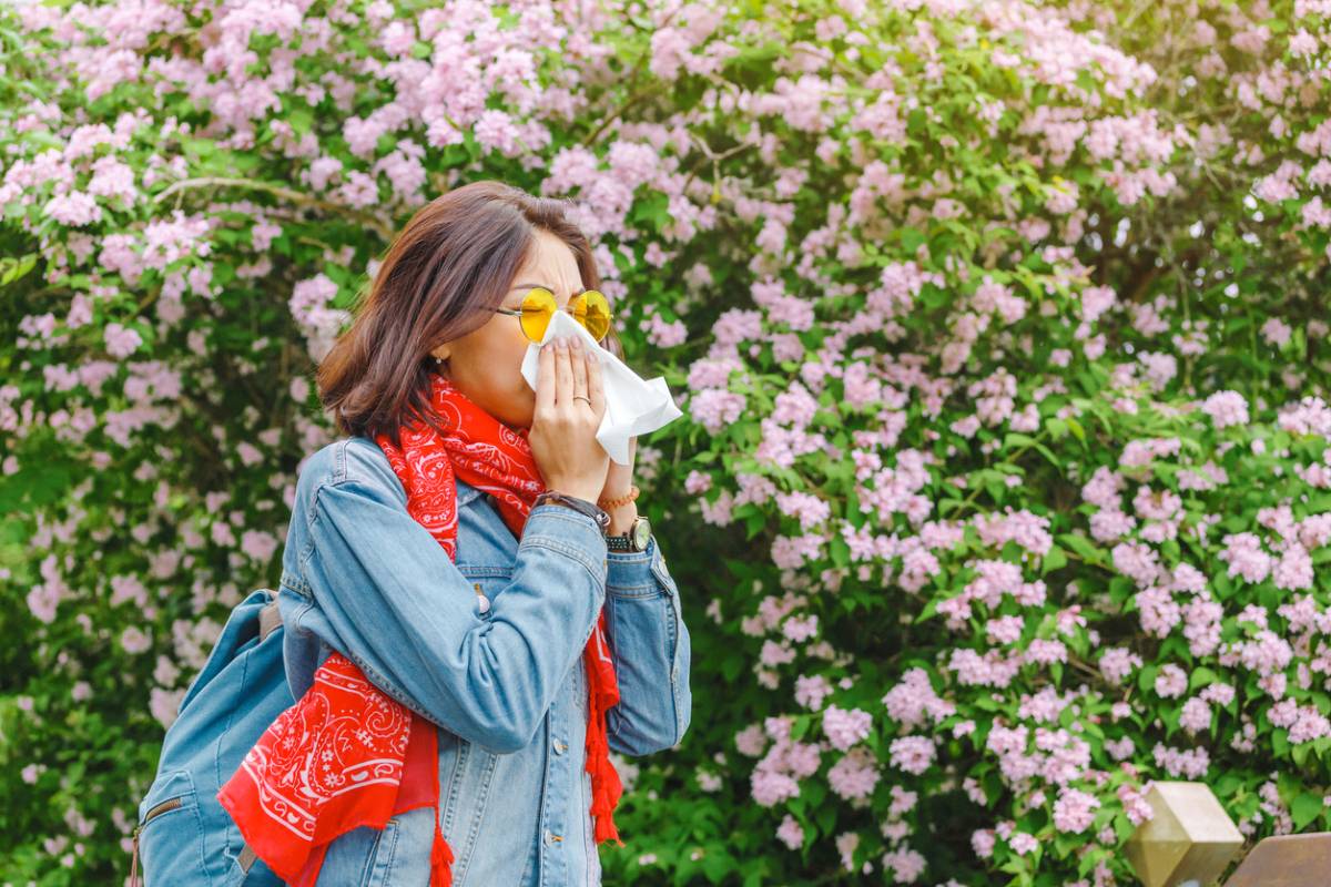 Woman sneezing and wondering if allergies are genetic