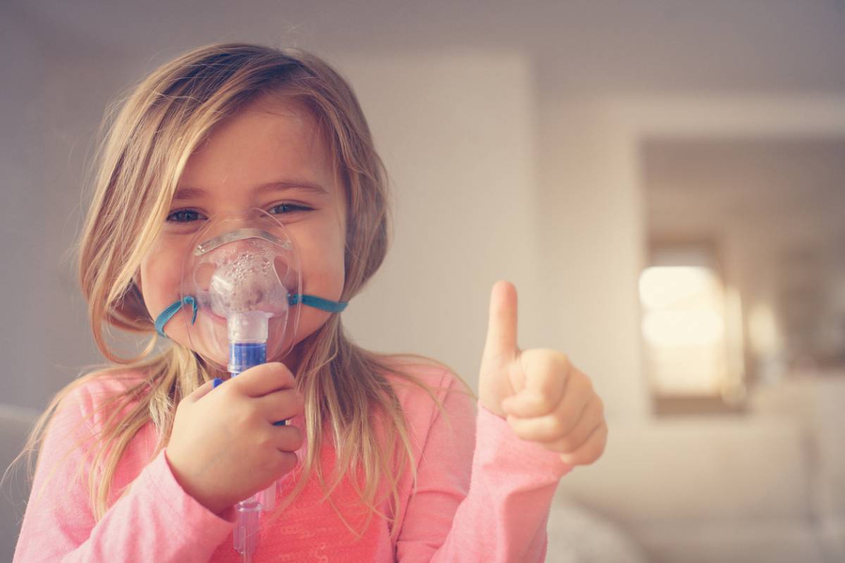 Child smiling using asthma inhaler techniques