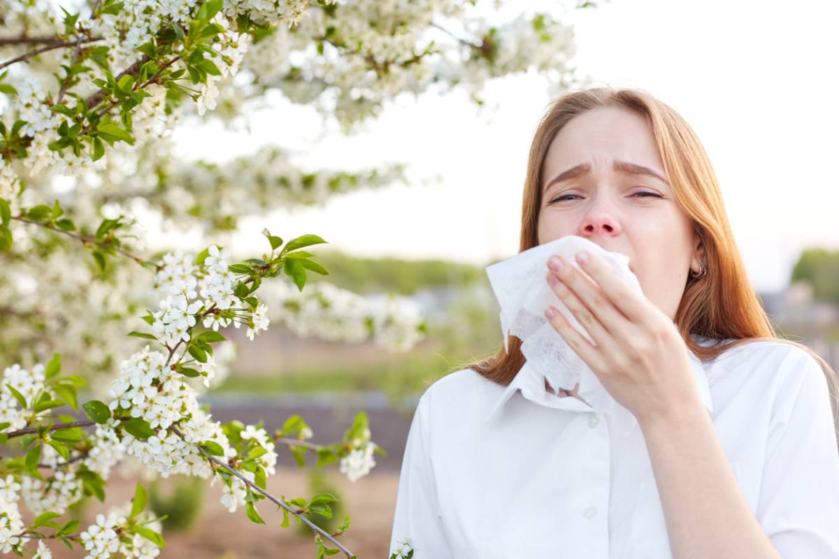 Woman sneezing when allergy season starts