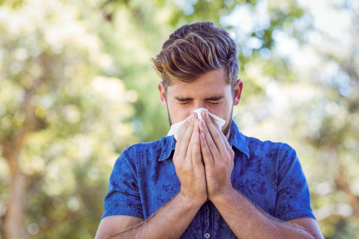 concept image of man trying to manage allergies in summer