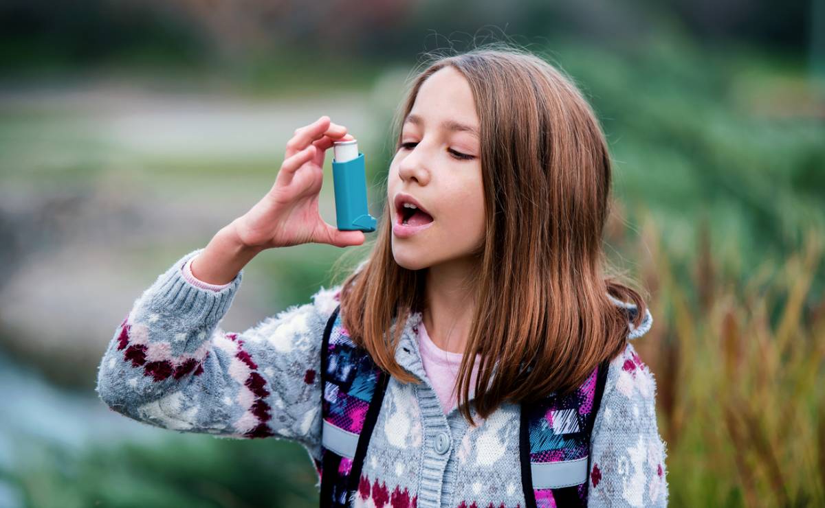 Little girl using asthma inhaler.